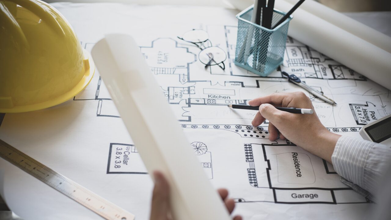 Architect reviewing architectural draughting drawings for house plans